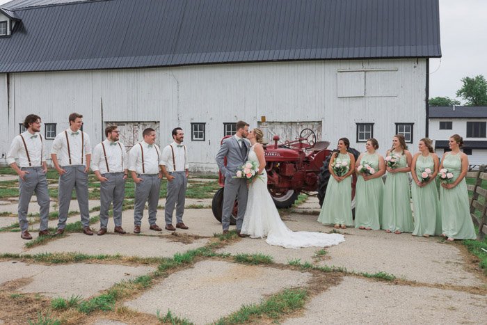 Una gran fiesta de bodas posa al aire libre en un área de corral: enfoque de la cámara para fotografías grupales nítidas 