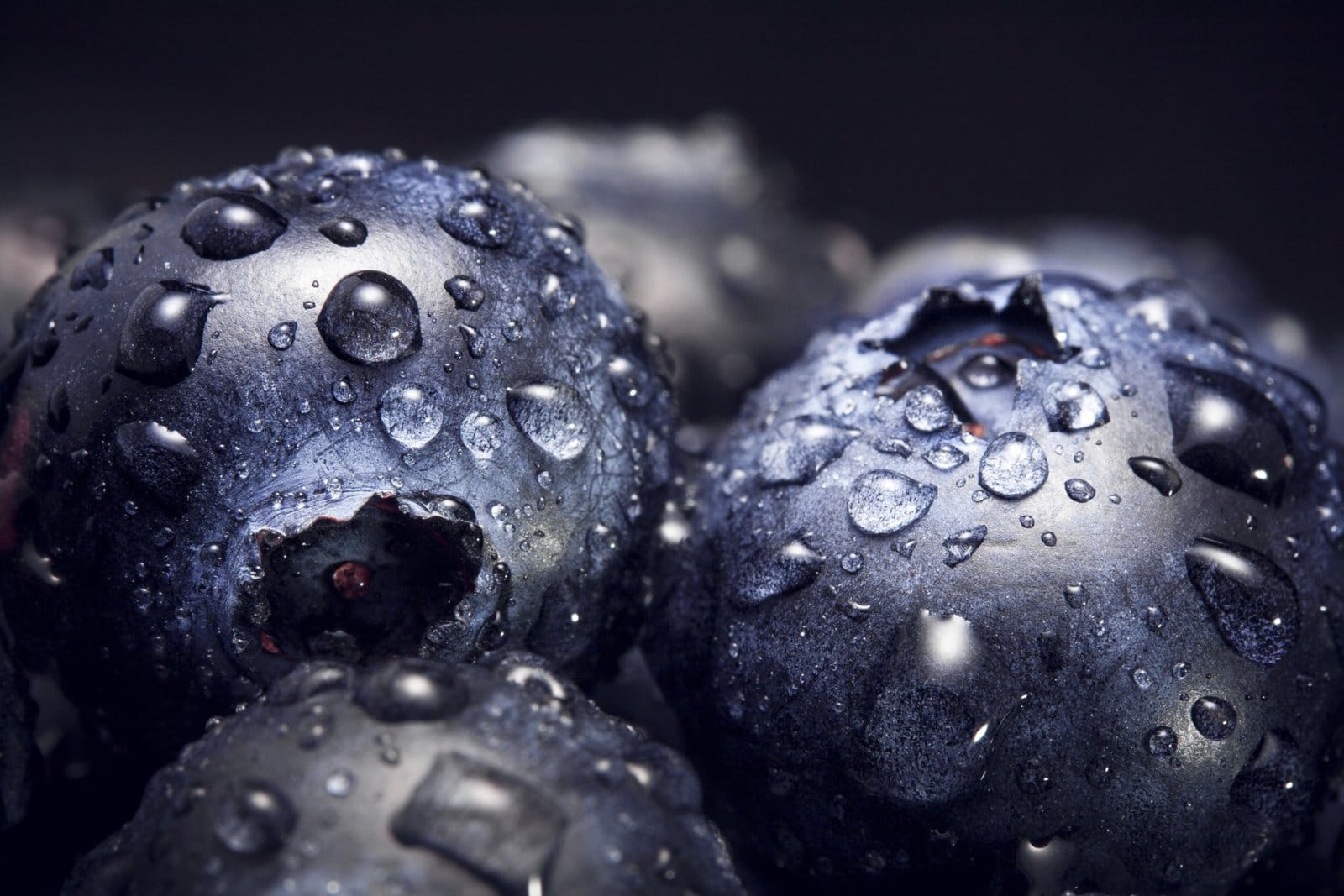 Configuración para fotografía macro: imagen de primer plano de arándanos con gotas de agua iluminadas con flash