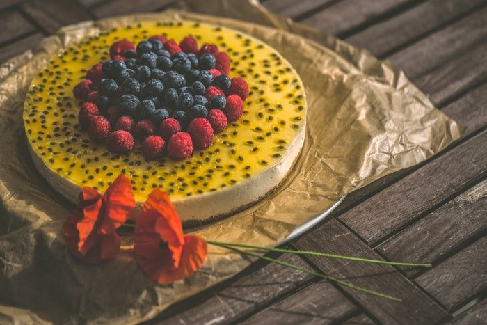 Fotografía de tarta de una tarta de queso con sabor a fruta sobre una mesa rústica