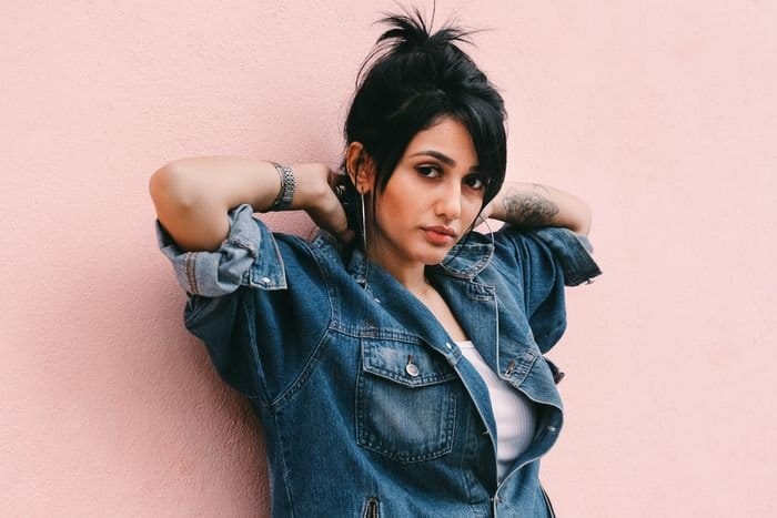 Foto de retrato de una mujer delante de una pared rosa