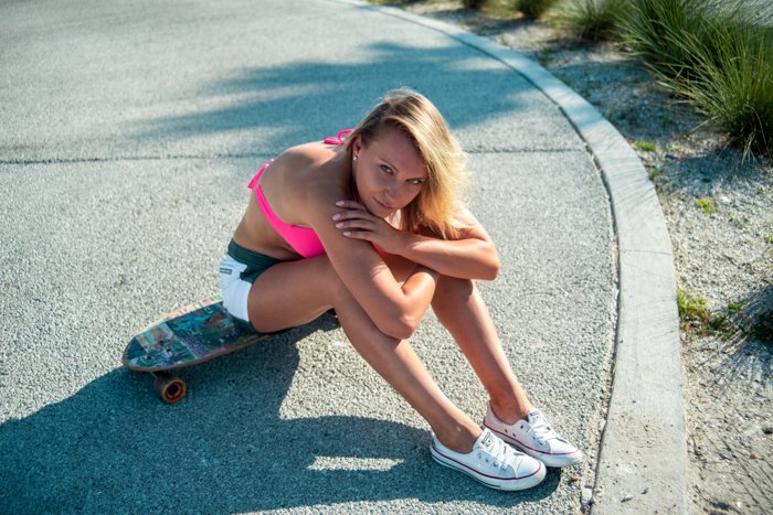 retrato al aire libre de un modelo femenino sentado en una patineta
