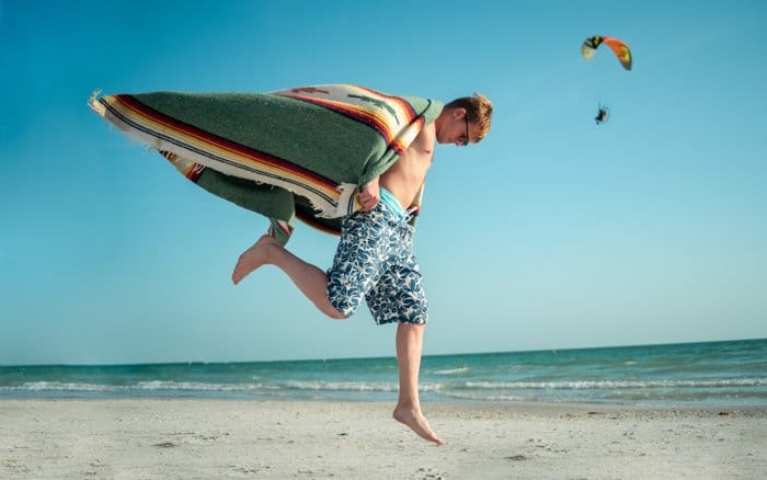 Retrato al aire libre de un modelo masculino jugando en la playa