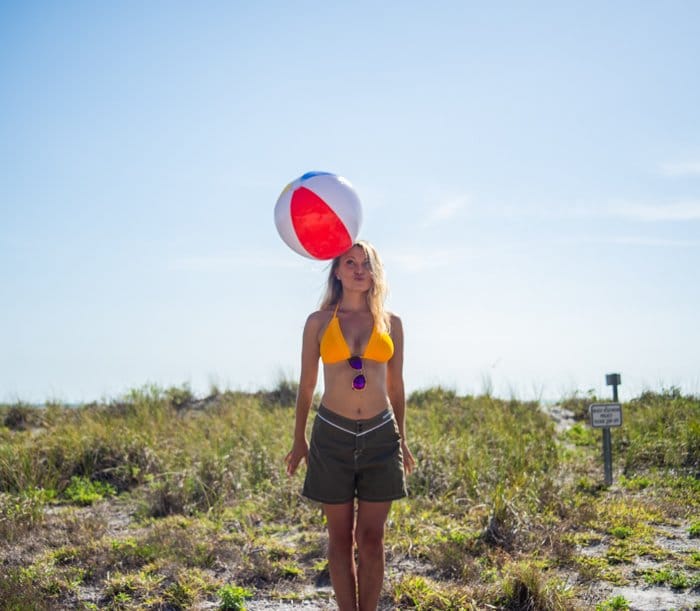 Retrato al aire libre de un modelo femenino jugando con una pelota de playa