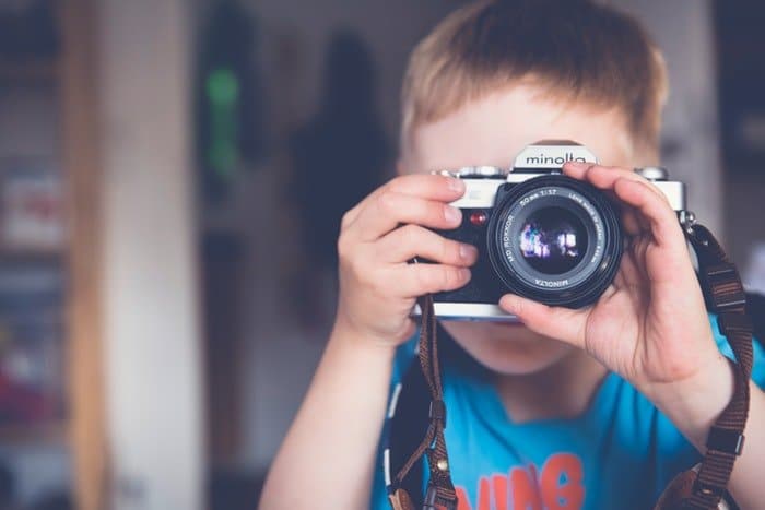 un niño tomando fotos con una cámara minolta