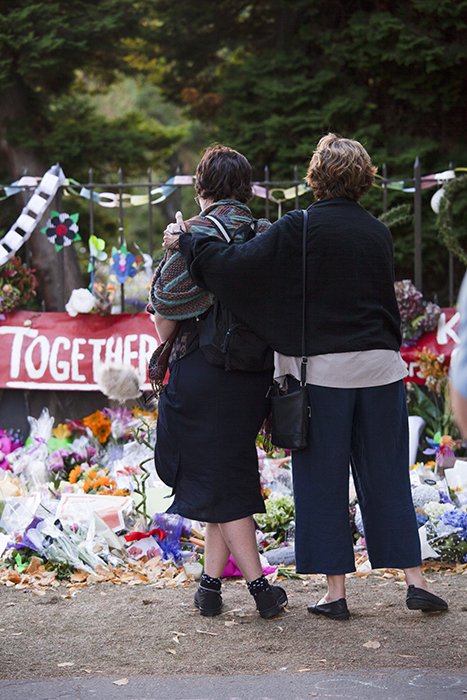 Foto de calle sincera de dos mujeres consolándose entre sí por un monumento