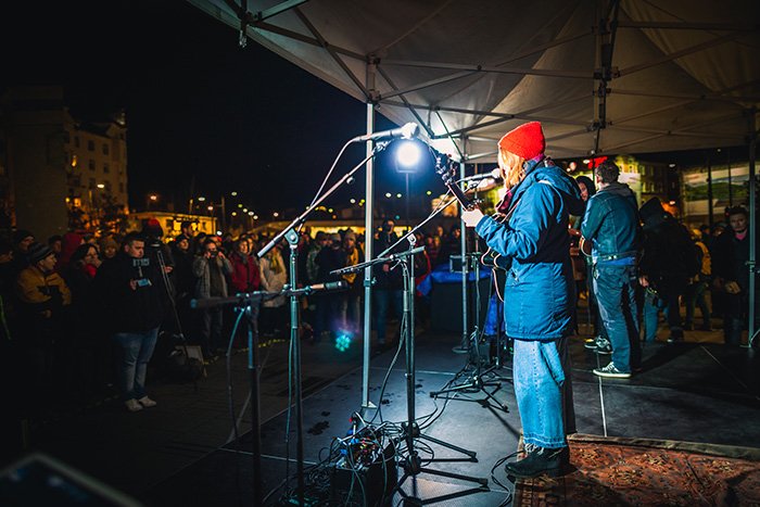 Una banda actuando en un evento al aire libre por la noche. 