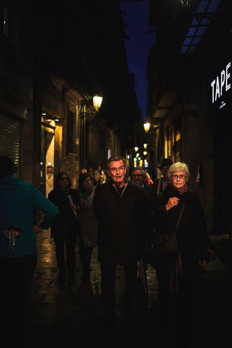 Gente caminando por calles concurridas por la noche.