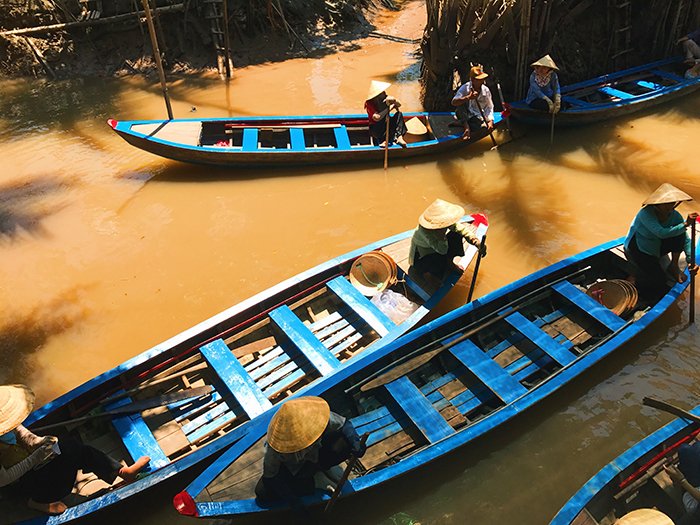 Fotografía cenital de personas remando botes de madera en un río: la mejor calidad de luz para el día
