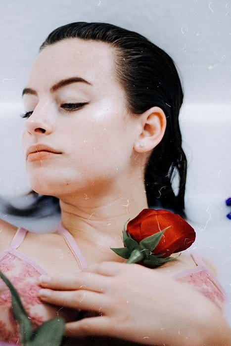 Baño de leche sensual retrato de una modelo femenina con accesorios de fotografía de tocador