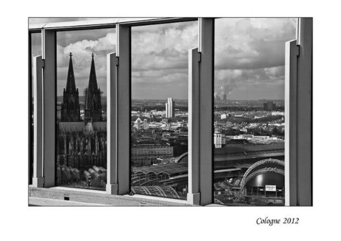 Una foto en blanco y negro de un paisaje urbano filmada a través de una ventana 