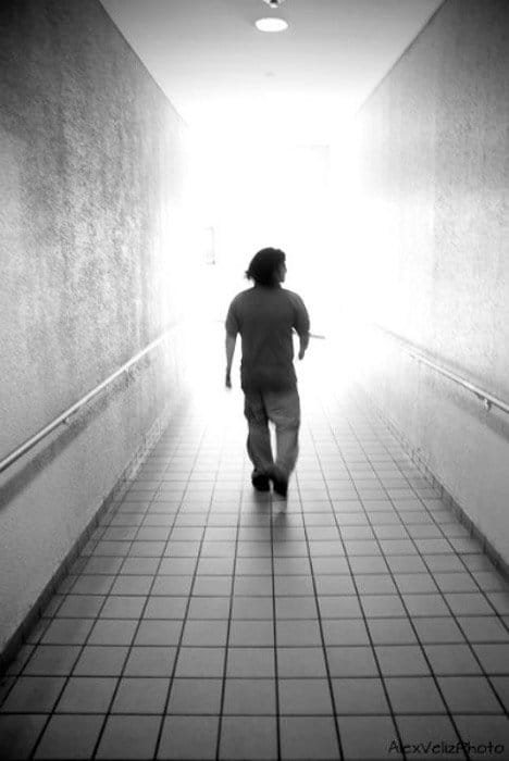 Una foto en blanco y negro de un hombre caminando por un pasillo