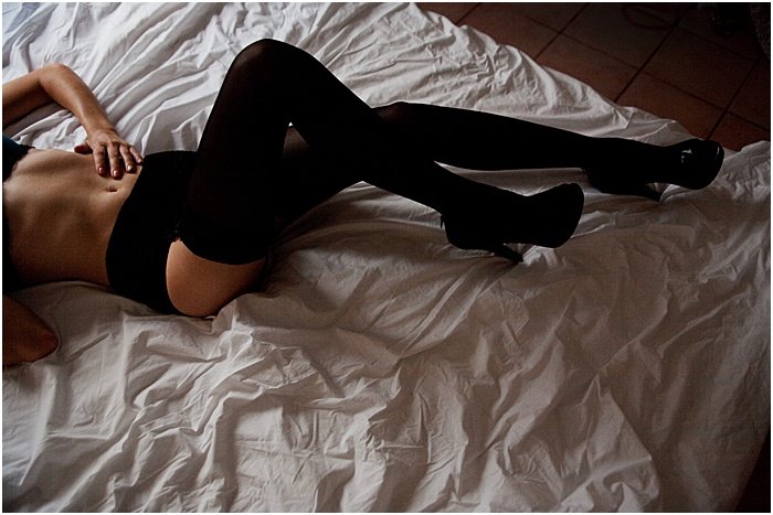Foto de boudoir de una mujer con medias negras fotografiada desde arriba