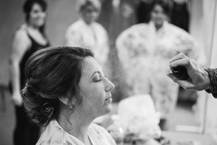 Una foto en blanco y negro de una novia maquillándose