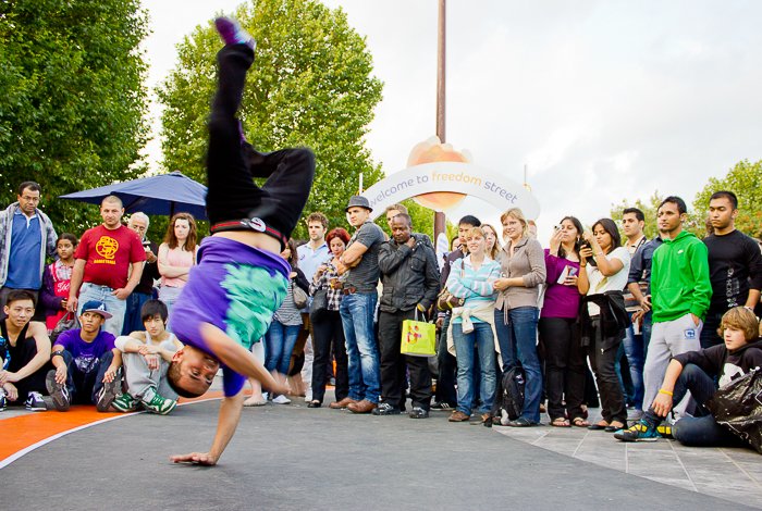 Un chico break dance en el Thames Festival con una multitud mirando 