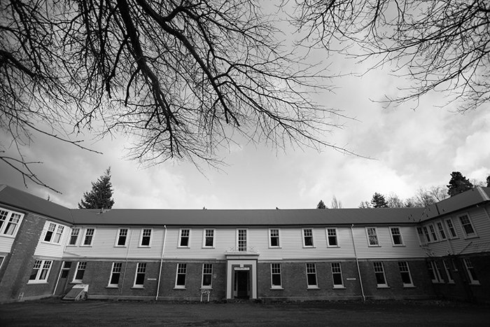 Foto en blanco y negro del frente del albergue de enfermeras del Hospital Queen Mary, ramas desnudas en un árbol cercano
