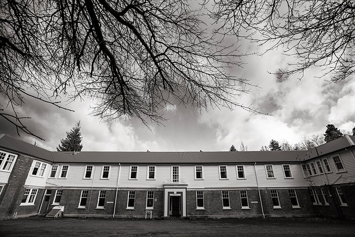 foto en blanco y negro del frente del albergue de enfermeras del Hospital Queen Mary, ramas desnudas en un árbol cercano, tonos ajustados para resaltar más detalles en la foto