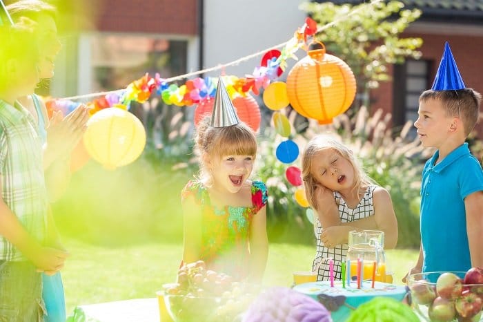 Niños felices con sombreros de fiesta divirtiéndose en una fiesta de cumpleaños