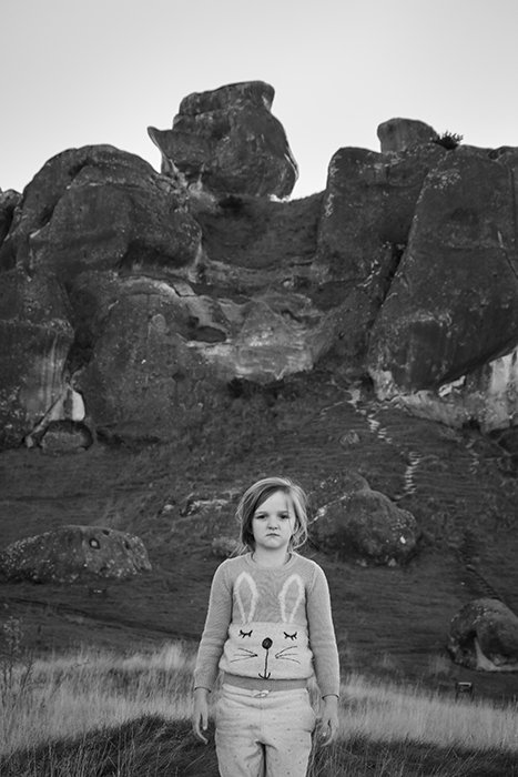 Un niño posando delante de las rocas en Castle Hill, Nueva Zelanda.  Consejos para la fotografía en blanco y negro