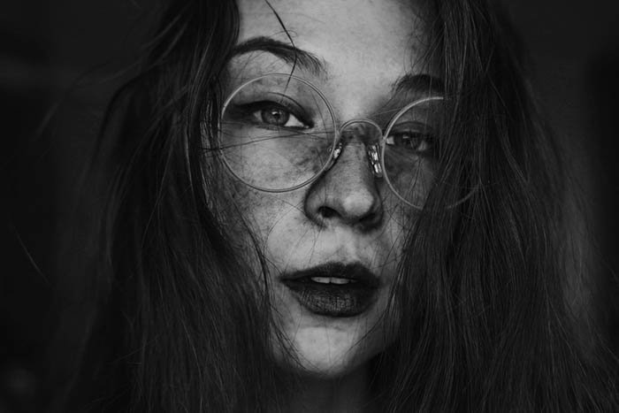 Autorretrato femenino creativo con gafas redondas.
