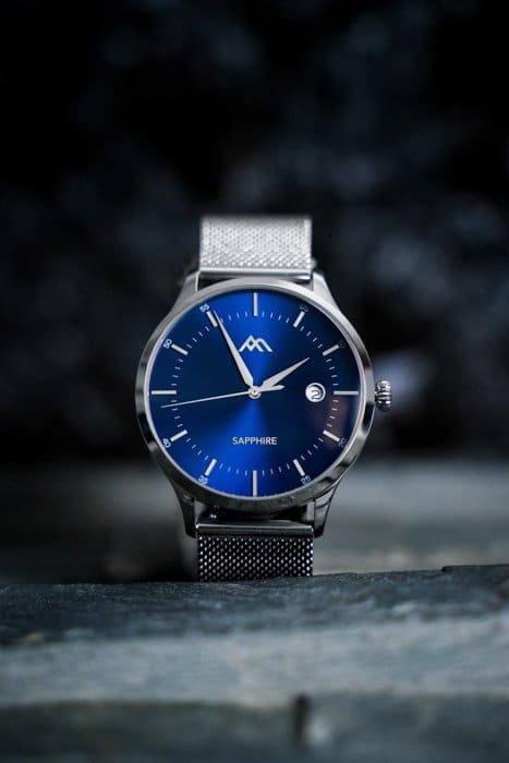 Imagen de fotografía de producto de un costoso reloj plateado con cara azul
