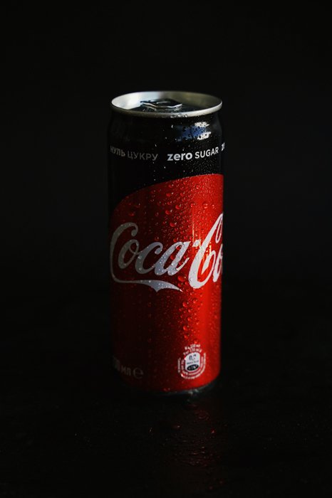 Fotografía de producto foto de una lata de Coca Cola con un fondo de estudio negro