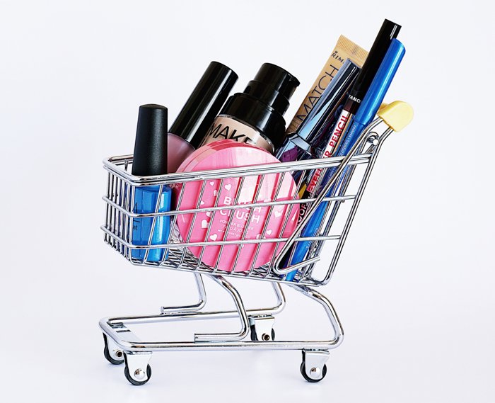 Imagen de fotografía de producto de un carrito de compras en miniatura con productos cosméticos