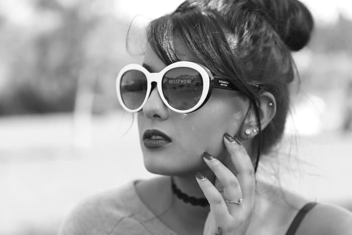 Fotografía de producto en blanco y negro Foto de cabeza de un modelo con un reflejo en gafas de sol con montura blanca