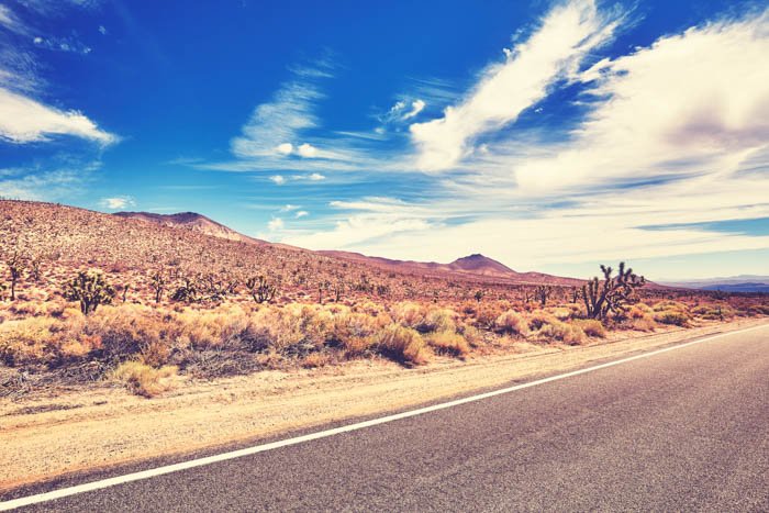 Una imagen saturada de una carretera y el desierto detrás de ella