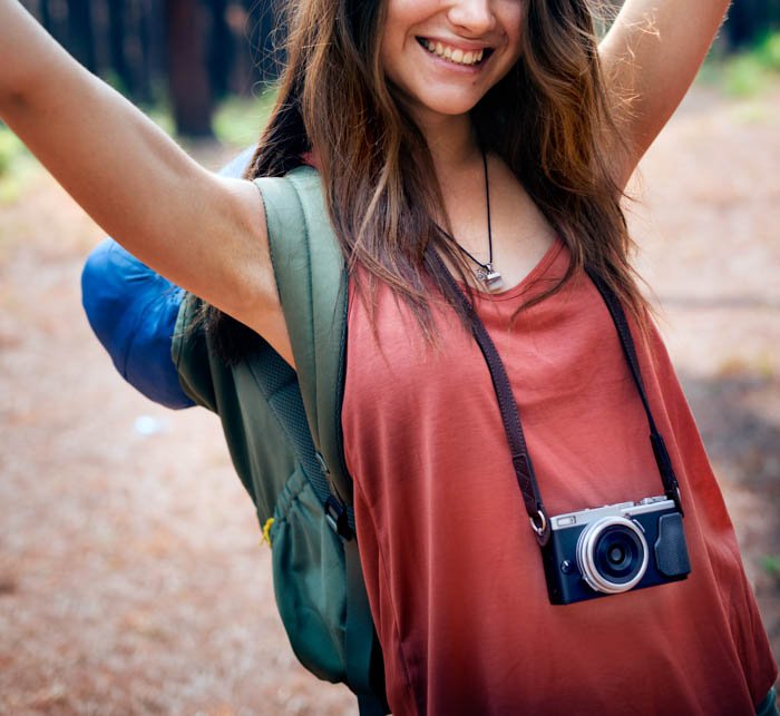 Una joven fotógrafa de viajes posando con su cámara