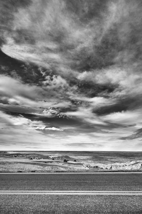 Una fotografía en blanco y negro de un camino y las nubes.