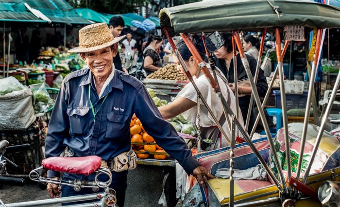 Una fotografía documental de viaje de un hombre asiático en un mercado callejero