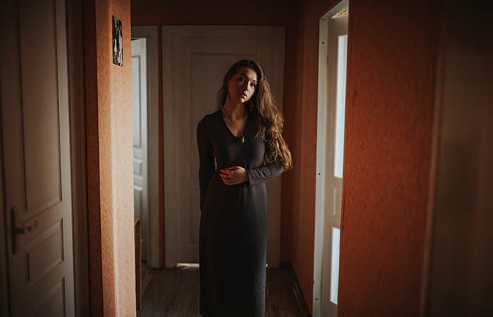 Retrato de interior de una niña con vestido largo gris - Fotografía de retrato con luz natural