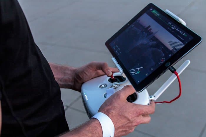 Imagen de un hombre que usa una tableta para controlar la fotografía de paisajes con drones