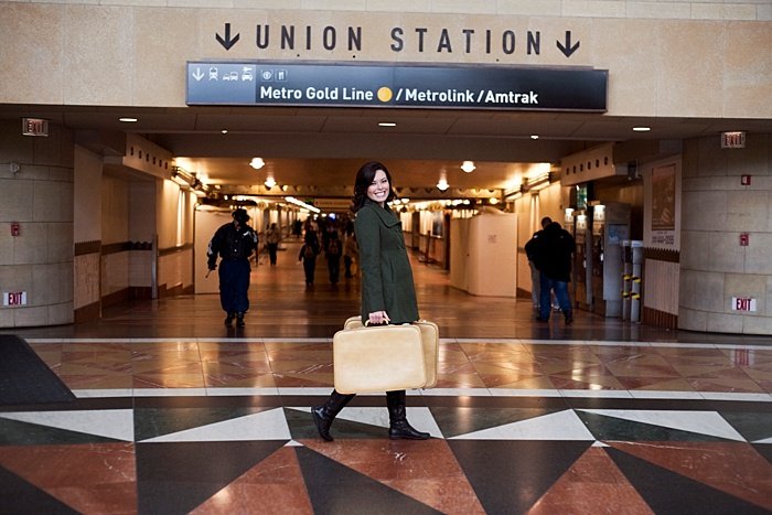Un retrato ambiental de una niña con maletas posando en union station
