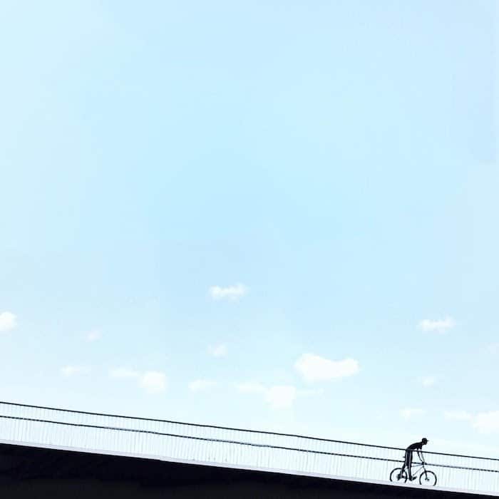Una foto minimalista de un ciclista en el puente.