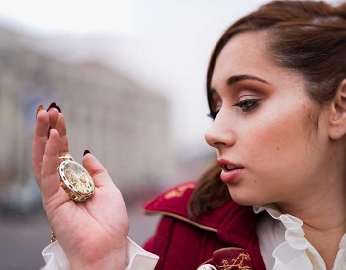 foto retrato de una niña sosteniendo un reloj de bolsillo