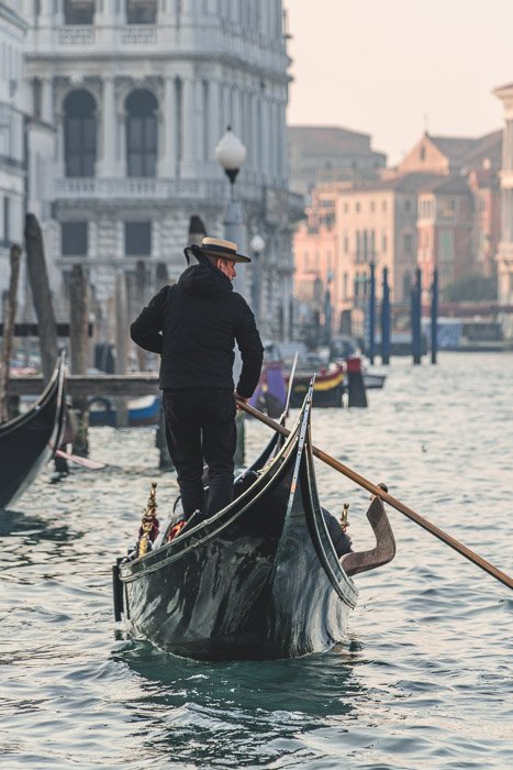 Foto de un hombre en una góndola en Venecia tomada con poca profundidad de campo.
