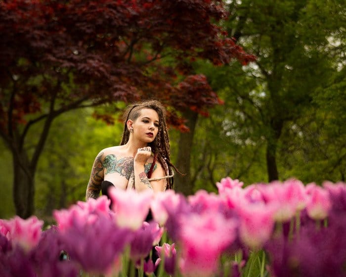 Foto de una mujer en un campo de tulipanes rosados ​​- poca profundidad de campo