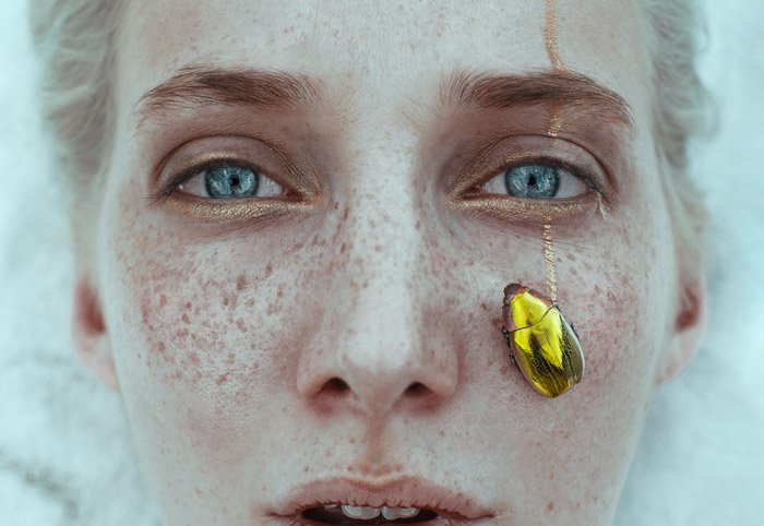 Ciro Galluccio creativo retrato de cerca de una hembra con un escarabajo dorado en su mejilla.  Fotógrafos de retratos famosos 