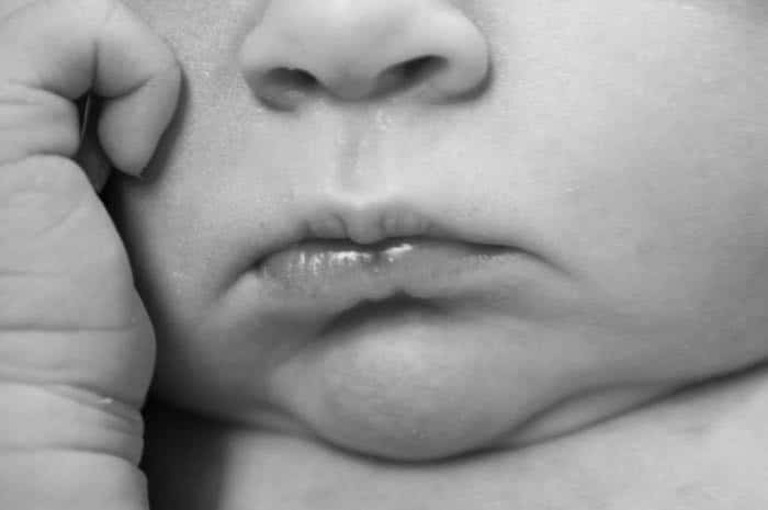 Fotografía de recién nacidos detalles de la foto de la nariz, la boca y la palma de la mano del bebé.