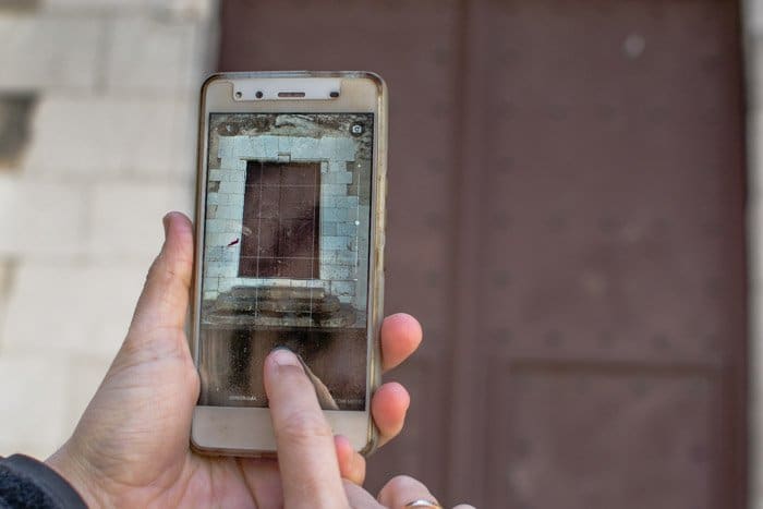 Usar un teléfono inteligente para fotografiar el marco de una ventana en una caminata fotográfica