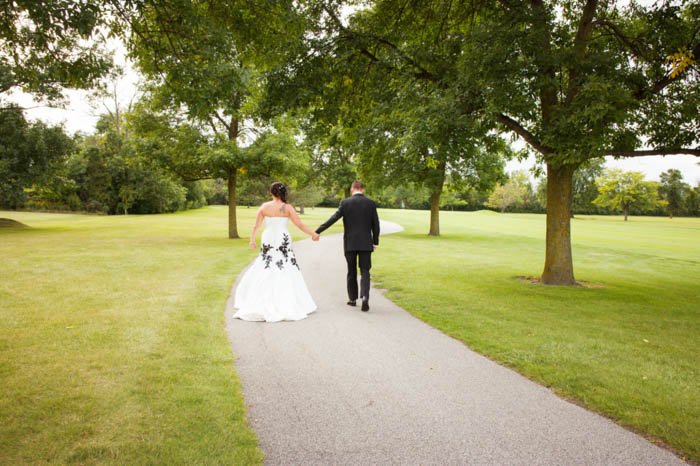 Una novia y el novio posando al aire libre alejándose de la cámara