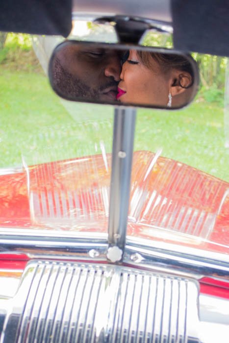 Reflejo de espejo de coche de una pareja de recién casados ​​besándose