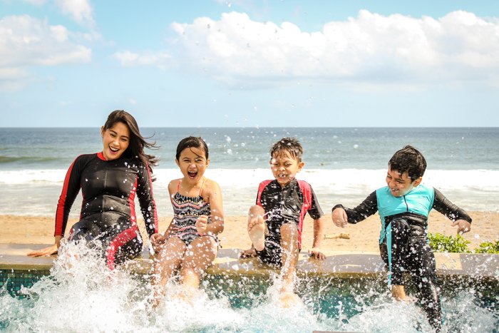 Fotos familiares de 4 niños jugando en el mar