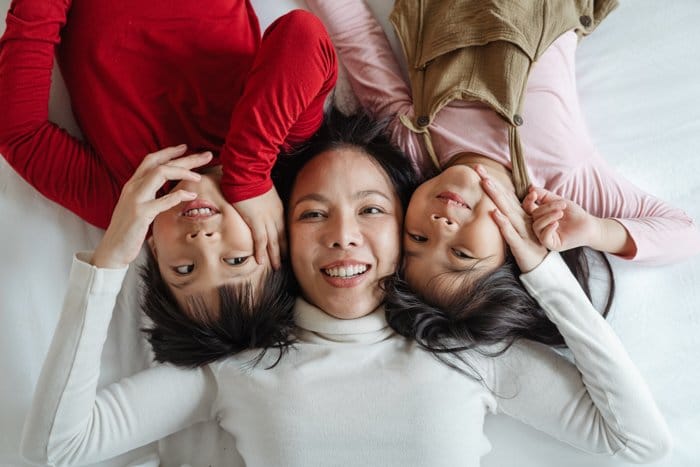 tres mujeres fotografiadas en la cama desde arriba
