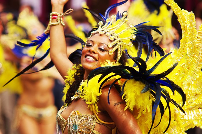 Un retrato de una bailarina de carnaval con un extravagante vestido de plumas amarillas