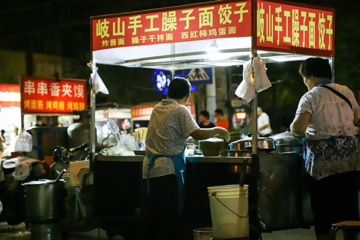 Un mercado de comida callejera por la noche.
