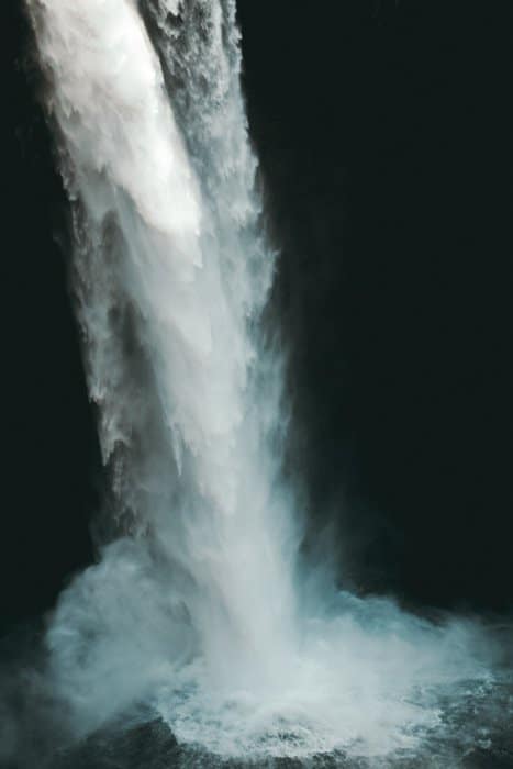 Una cascada que fluye golpeando un charco de agua.