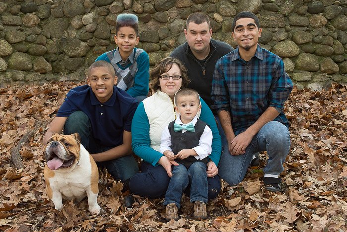 Un retrato de familia de seis personas posando con las mascotas de la familia.