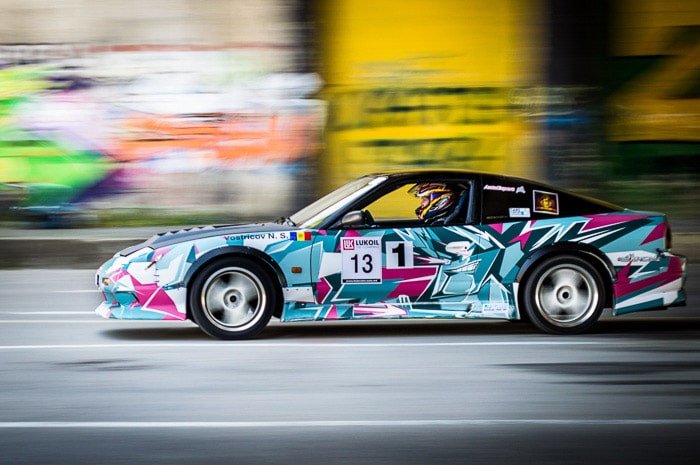 Un colorido coche de carreras con fondo de desenfoque de movimiento